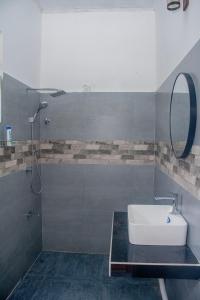 une salle de bain avec un lavabo et une douche avec un miroir dans l'établissement Red Araliya Villa Weligama, à Weligama