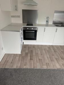 a kitchen with white cabinets and a stove at Manchester Guesthouse in Manchester