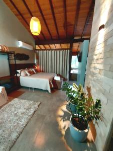 a bedroom with a bed and a potted plant at Recanto Lua de Lumiar in Nova Friburgo +29 photos
