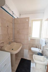 un bagno bianco con lavandino e WC di Love mer- Granelli a Granelli