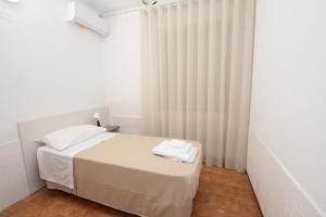 una camera da letto bianca con un letto con due asciugamani sopra di Love mer- Granelli a Granelli