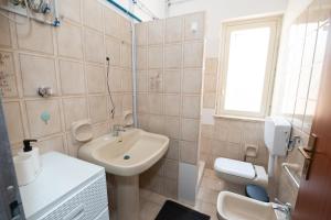 un bagno bianco con lavandino e WC di Love mer- Granelli a Granelli