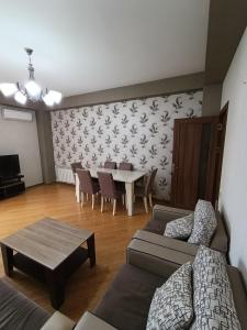 バクーにあるEntire rental unit in Baku, Whole Apartment 85m2のソファとテーブルと椅子のあるリビングルーム