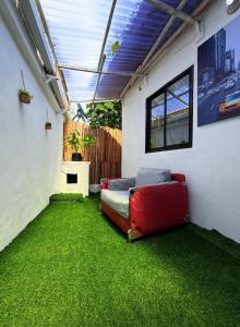 a living room with a red couch on green grass at Kath'shub garth in Lagos
