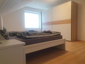 una cama en una habitación con ventana en Zur Kleinen Oertze, en Munster im Heidekreis
