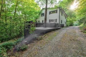 une maison sur un chemin de terre dans les bois dans l'établissement Paws A While, à Blowing Rock