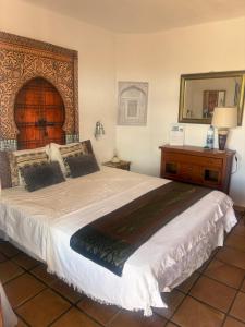 a bedroom with a large bed and a mirror at Guest House Ysabela Suite Privada y Habitaciones con Baño Compartido in Tías