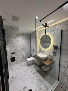 een badkamer met een wastafel en een spiegel bij TrikalaBnB - Prime Loft 2 in Tríkala