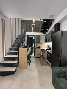 een keuken en een trap in een kamer bij TrikalaBnB - Prime Loft 2 in Tríkala