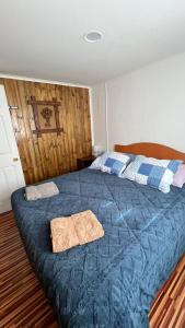 a bedroom with a blue bed with two towels on it at Che Manuel in Puerto Natales +27 photos
