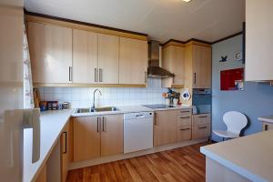 a kitchen with wooden cabinets and a white counter top at Fjord House in Fornes