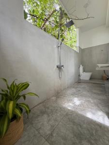 La salle de bains est pourvue d'une douche, de toilettes et d'une plante. dans l'établissement Shoreline House Hiriketiya, à Nilwella 197 autres photos