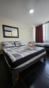a bedroom with a bed with a checkered blanket at Departamentos Amoblados R&M in Santiago