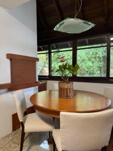 una mesa de comedor con sillas y una maceta. en Apartamento Petri Bavaria, en Gramado