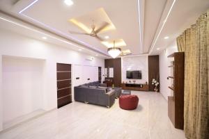 a living room with a couch and a ceiling fan at The Laxmi Royale Villa in Jaipur