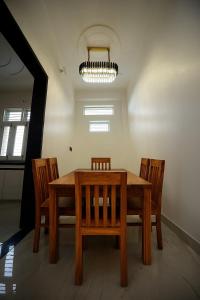 Un comedor con mesa y sillas de madera. en The Laxmi Royale Villa, en Jaipur