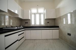 Una cocina con gabinetes blancos y encimeras negras. en The Laxmi Royale Villa, en Jaipur 18 fotos más