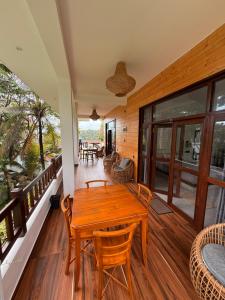 - une table en bois sur le balcon d'une maison dans l'établissement Shoreline House Hiriketiya, à Nilwella
