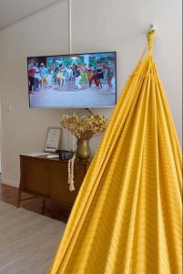 a large yellow cape in a living room with a television at Apto con terraza privada junto al Bulevar del Rio y Calle del Sabor in Cali
