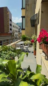 a balcony with a table and flowers on a building at Apartamento con terraza privada junto al Bulevar del Rio in Cali