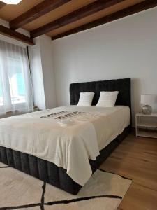 a bedroom with a large bed with a black headboard at appartement confortable en centre ville in Montreux