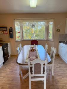 a kitchen with a wooden table and a table and chairs at Landlig hus på kysten in Tustna