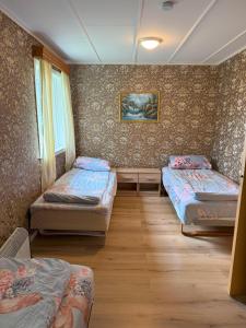 a room with three beds and a window at Landlig hus på kysten in Tustna