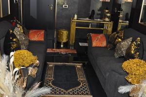 - un salon avec un canapé gris et des oreillers dans l'établissement SAHARA chic, à Reggio de Calabre