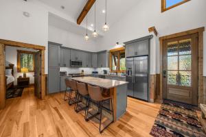 バナー・エルクにあるBear Woods Belle at Eagles Nestのグレーのキャビネット付きのキッチン、バースツール付きの島