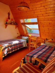 a bedroom with two beds and a window in a log cabin at Casa Claudia in Carano