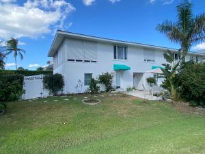 a white house with a yard at Closest Studio Suite to Vanderbilt Beach, remodeled inside & out, new Anderson windows & sliders, well appointed, best quality throughout, fenced yard, private plus many extras! in Naples