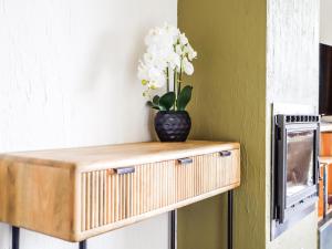 een vaas met witte bloemen bovenop een plank bij Castelgolf in Vesin