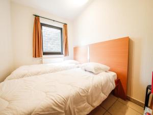 een slaapkamer met twee bedden en een raam bij Castelgolf in Vesin +7 foto's