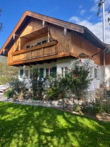a house with a balcony on top of a yard at Landhaus Falkennest in Flintsbach am Inn