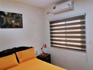a bedroom with a yellow bed and a window at Hotel El Rio in Bahía de Caráquez