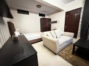 a living room with a couch and a bed at The Perfect Cozy Studio In Abu Dhabi in Abu Dhabi