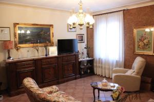 a living room with a couch and a tv at La Casa di Famiglia tra Siena, Chianti e Crete in Castelnuovo Berardenga