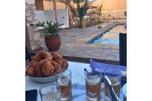 a table with a bowl of food and a swimming pool at Villa avec piscine 15 minutes de l'aéroport in Essaouira