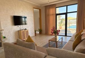 a living room with a couch and a flat screen tv at Villa avec piscine 15 minutes de l'aéroport in Essaouira