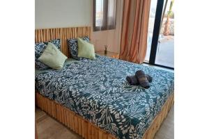 a bed with a blue and white blanket and pillows at Villa avec piscine 15 minutes de l'aéroport in Essaouira +25 photos
