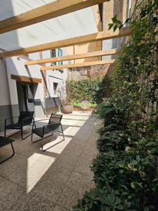 Downtown suite in Reggio Emilia relax e lavoro في ريجيو إيميليا: فناء فيه كرسيين وطاولة وبعض النباتات