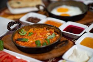 a bowl of food on a table with eggs and other condiments at AHISKA PALAS OTEL in Kars