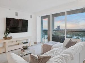a living room with a white couch and a tv at Coconut Grove Elegance Five Star Condo Living in Miami