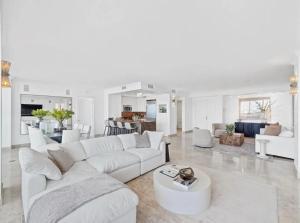 a white living room with a white couch and a table at Coconut Grove Elegance Five Star Condo Living in Miami