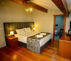 a bedroom with a large bed with a wooden floor at AHISKA PALAS OTEL in Kars