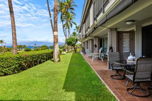 a patio with a table and chairs next to a building at Maui Eldorado Condo A104 in Kaanapali
