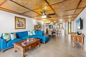 a living room with a blue couch and a table at Maui Eldorado Condo A104 in Kaanapali