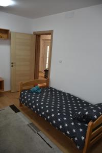 a bed in a room with a blue blanket with stars on it at Countryside rest house in Novi Banovci