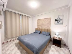 ハジャイにあるS Home Hat Yai - Entire House, Private Parkingの青いシーツのベッドと窓のある寝室
