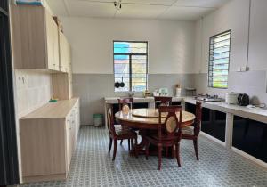 ラブアンにあるAyana Homestayのキッチン(テーブル、椅子付)